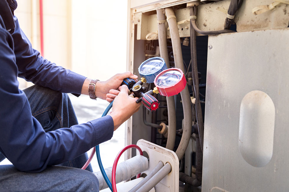 a person is checking the HVAC system with pressure guaze